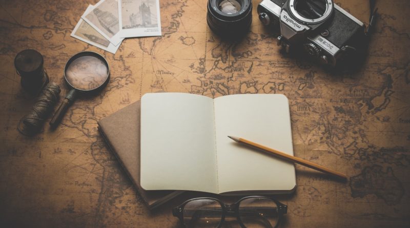 flat ray photography of book, pencil, camera, and with lens