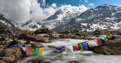 assorted-color of apparel hanged below creek across glacier mountain