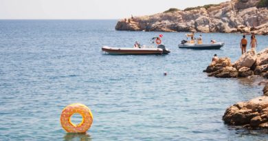 group of people swimming on body of water during daytime