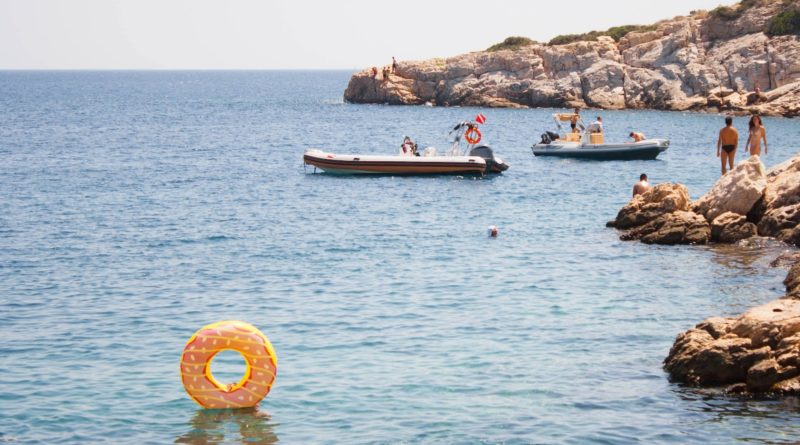 group of people swimming on body of water during daytime