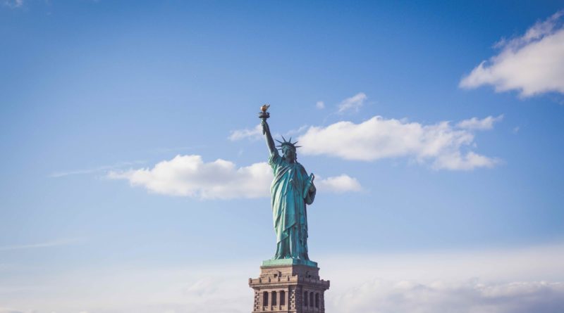 Statue of Liberty, New York under white and blue cloudy skies