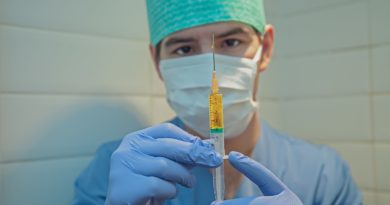 person in blue knit cap holding clear glass tube