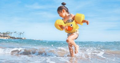 girl playing beside body of water during daytime