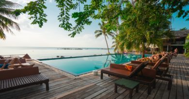 brown wooden table and chairs on brown wooden deck near body of water during daytime