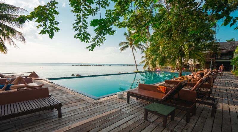 brown wooden table and chairs on brown wooden deck near body of water during daytime