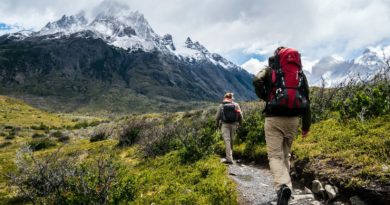 two person walking towards mountain covered with snow